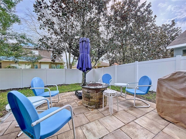 view of patio / terrace with an outdoor fire pit, a fenced backyard, and a grill