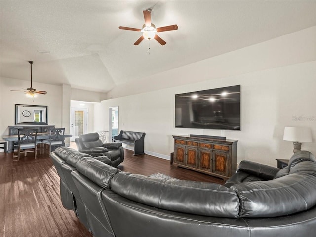 living room with dark wood-style floors, vaulted ceiling, a ceiling fan, and baseboards