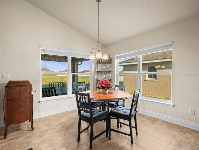 dining space with baseboards, vaulted ceiling, and tile patterned floors