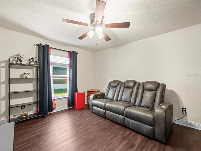 living area with dark wood-style floors, ceiling fan, baseboards, and a textured ceiling