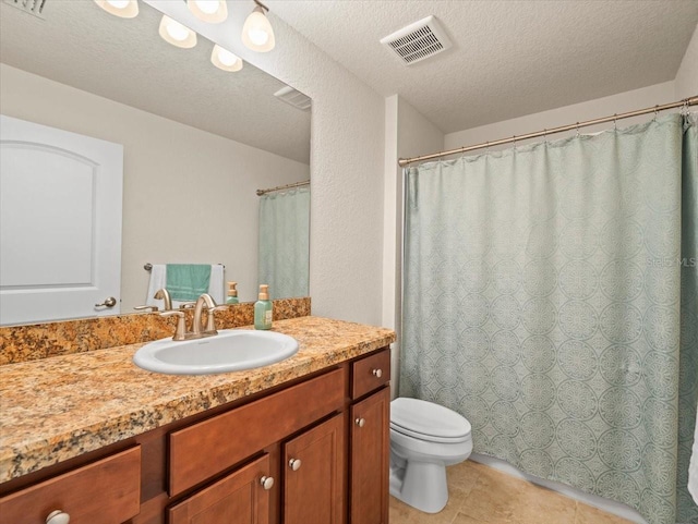 bathroom with a textured ceiling, tile patterned flooring, toilet, vanity, and visible vents