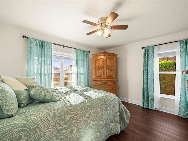 bedroom with a ceiling fan, baseboards, and wood finished floors