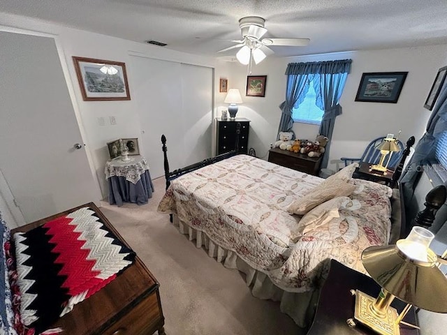 bedroom featuring carpet, a closet, visible vents, ceiling fan, and a textured ceiling