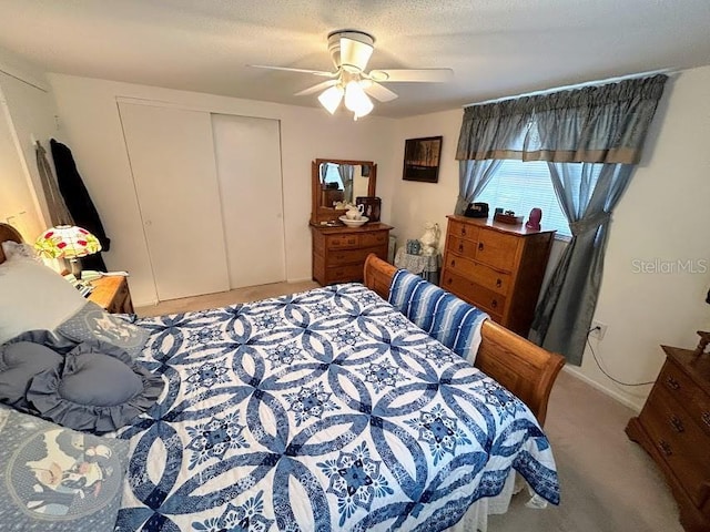 carpeted bedroom featuring ceiling fan, a textured ceiling, and a closet