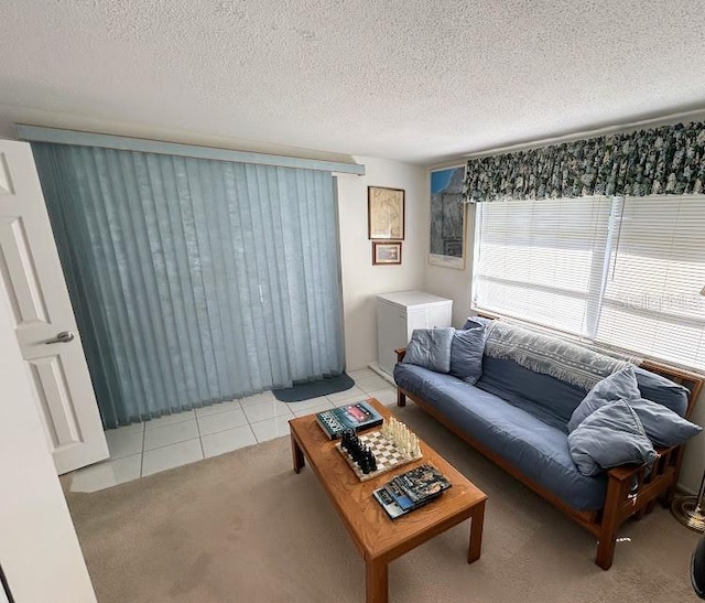 carpeted living area with a textured ceiling and tile patterned floors