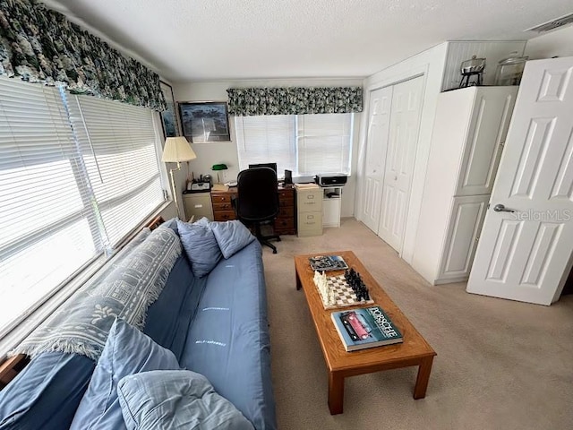 living room featuring light carpet, visible vents, and a textured ceiling