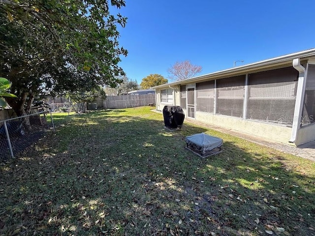 view of yard with a sunroom and a fenced backyard