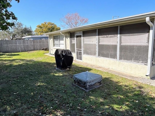 view of yard with a sunroom and fence