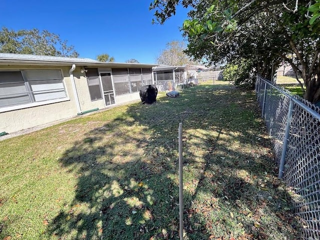 view of yard with a sunroom and fence