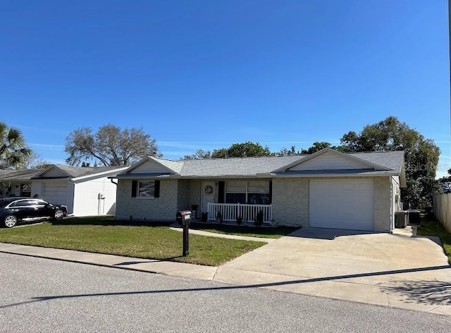 ranch-style home featuring covered porch, fence, a garage, driveway, and a front lawn