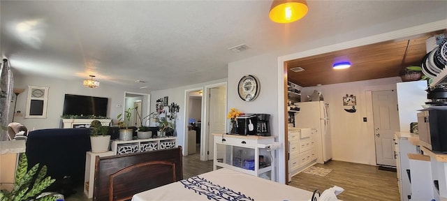 kitchen featuring visible vents, light countertops, dark wood finished floors, and freestanding refrigerator