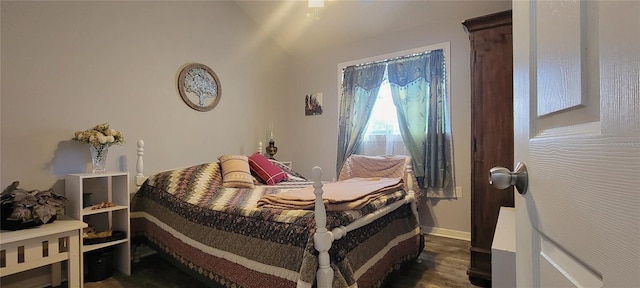 bedroom with dark wood-style flooring