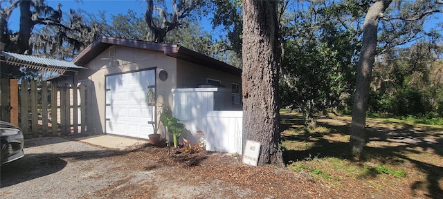 view of side of property featuring a garage, an outbuilding, and driveway