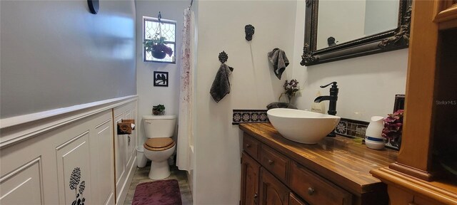 6825 Main St, New Port Richey, FL 34653 - bathroom featuring vanity and wainscoting