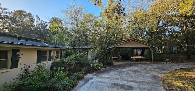 exterior space with concrete driveway and a detached carport