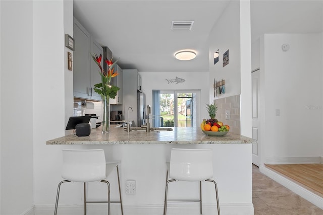 6027 Bayside Key Dr, Tampa, FL 33615 - kitchen featuring a peninsula, a sink, visible vents, gray cabinets, and tasteful backsplash