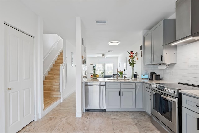 6027 Bayside Key Dr, Tampa, FL 33615 - kitchen with visible vents, gray cabinetry, appliances with stainless steel finishes, a sink, and wall chimney exhaust hood