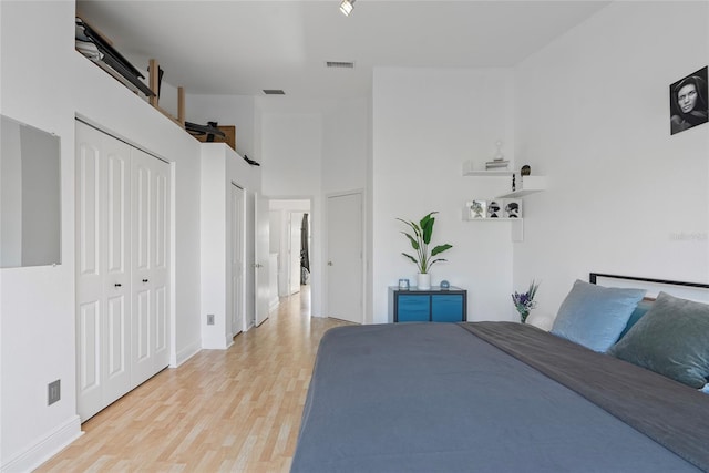 6027 Bayside Key Dr, Tampa, FL 33615 - unfurnished bedroom with light wood-style floors, visible vents, a towering ceiling, and a barn door