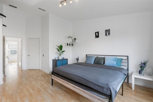 6027 Bayside Key Dr, Tampa, FL 33615 - bedroom with light wood-type flooring, a towering ceiling, visible vents, and baseboards