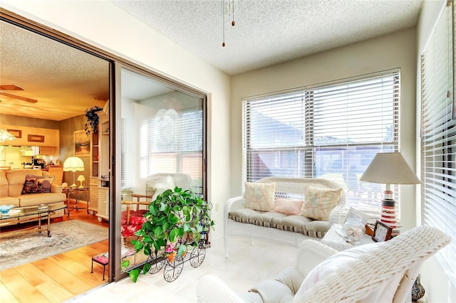 interior space with a textured ceiling, wood finished floors, and a ceiling fan