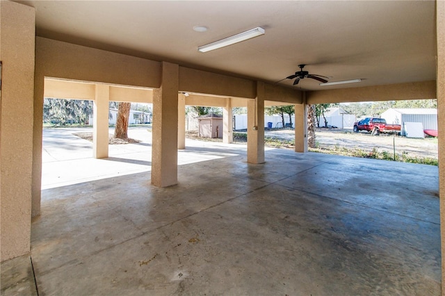 garage featuring ceiling fan and a storage shed