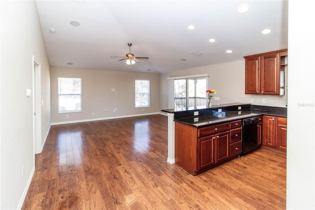 kitchen with black dishwasher, a peninsula, open floor plan, and wood finished floors