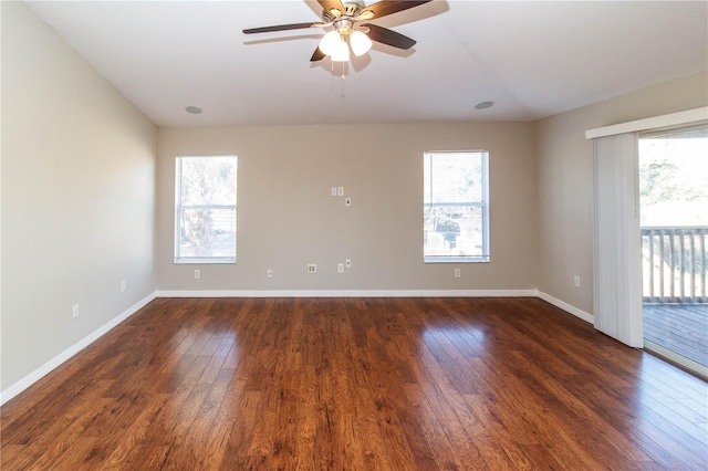 spare room with a healthy amount of sunlight, dark wood finished floors, and baseboards