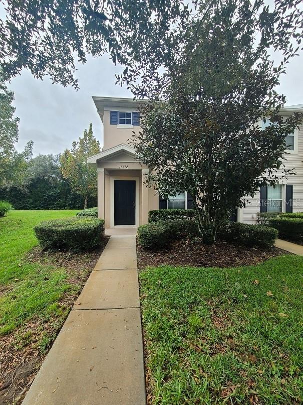 obstructed view of property with a front yard and stucco siding