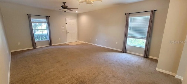 unfurnished room featuring baseboards, a ceiling fan, and light colored carpet