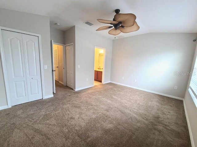 unfurnished bedroom with carpet floors, multiple closets, lofted ceiling, visible vents, and baseboards