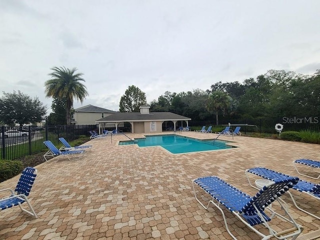 pool featuring a patio area and fence