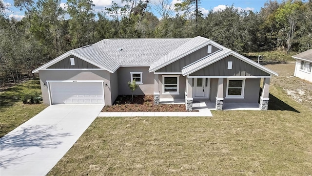 view of front of property with a garage, driveway, a front lawn, a porch, and stucco siding