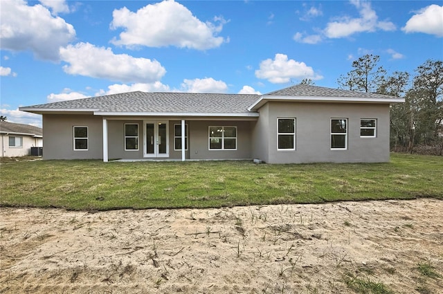 rear view of property with french doors, a lawn, central air condition unit, and stucco siding