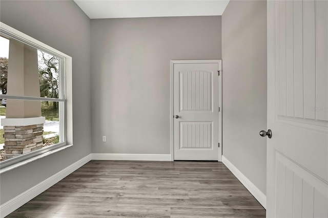 unfurnished room with baseboards and wood finished floors