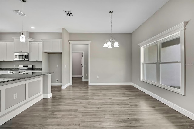 kitchen featuring white cabinets, appliances with stainless steel finishes, visible vents, and baseboards