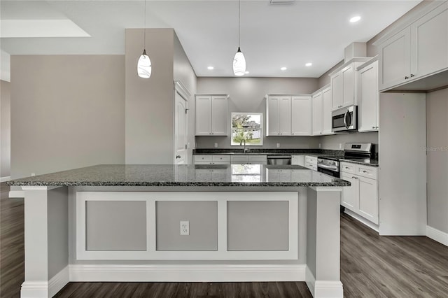 kitchen with white cabinetry, appliances with stainless steel finishes, a sink, and a center island