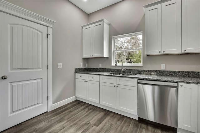 kitchen featuring dark stone countertops, dark wood-style flooring, a sink, and stainless steel dishwasher