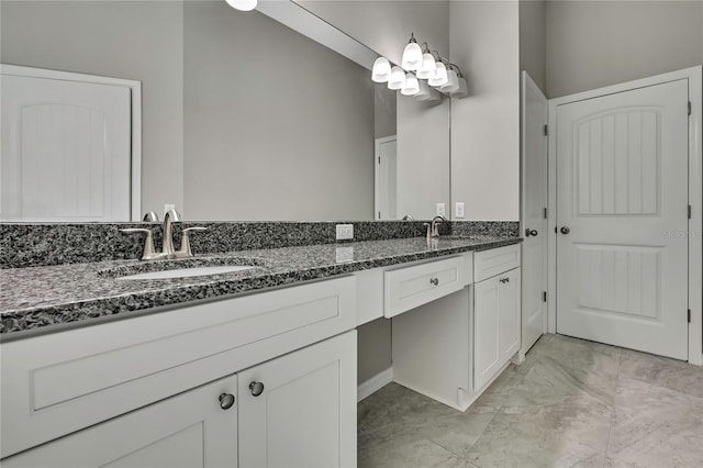 bathroom featuring marble finish floor, double vanity, and a sink