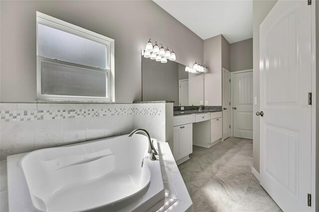 bathroom featuring a tub, marble finish floor, and vanity