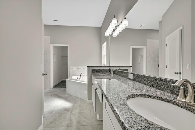 bathroom featuring double vanity, a garden tub, a tile shower, and a sink