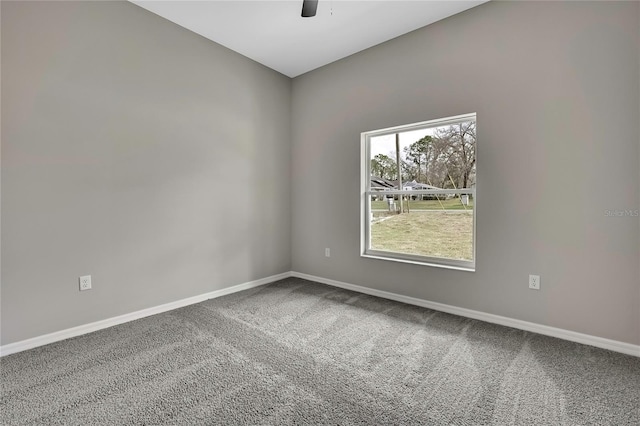 carpeted empty room with ceiling fan and baseboards