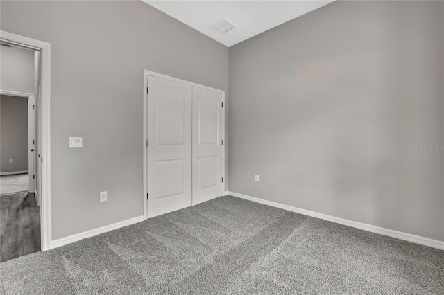 unfurnished bedroom with carpet floors, a closet, visible vents, and baseboards