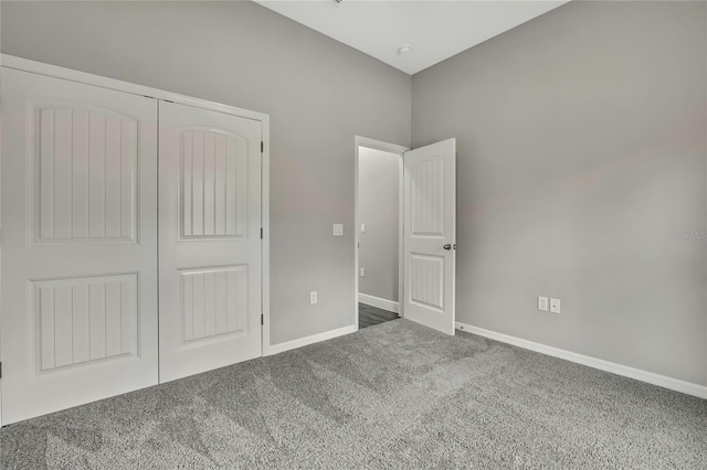 unfurnished bedroom featuring carpet floors, a closet, and baseboards