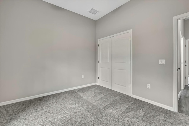 unfurnished bedroom with carpet floors, a closet, visible vents, and baseboards