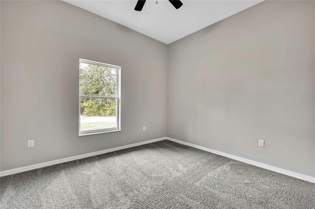 carpeted empty room with a ceiling fan and baseboards