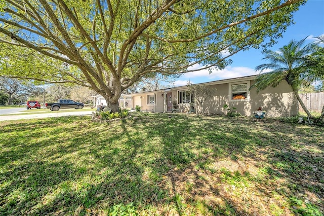 single story home with stucco siding and a front yard