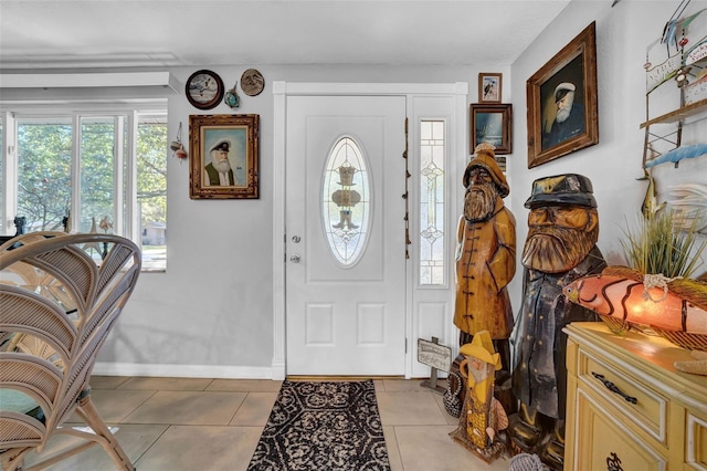 entrance foyer with light tile patterned floors and baseboards