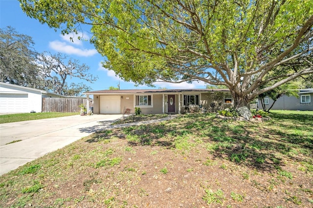 ranch-style house featuring stucco siding, concrete driveway, an attached garage, and fence