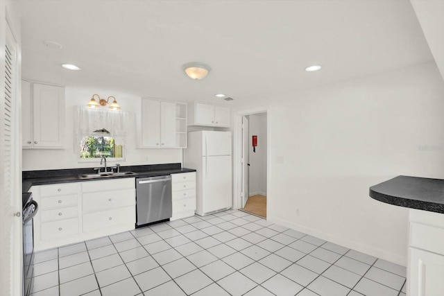 kitchen featuring a sink, white cabinetry, freestanding refrigerator, dishwasher, and dark countertops