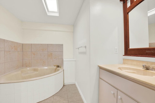 full bath with a skylight, vanity, a bath, and tile patterned floors